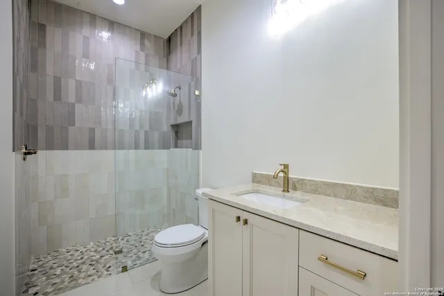 a bathroom with a granite countertop sink toilet and shower
