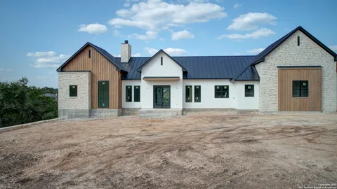 a front view of a house with yard and trees