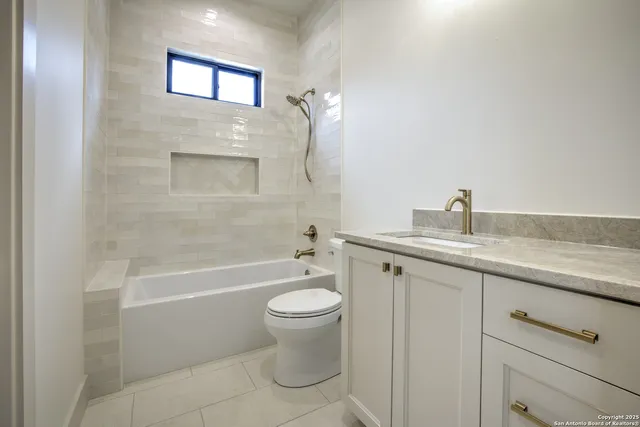 a bathroom with a granite countertop toilet a sink and bathtub