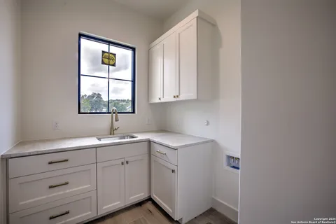 a kitchen with a sink cabinets appliances and a window