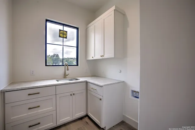 a kitchen with a sink cabinets appliances and a window