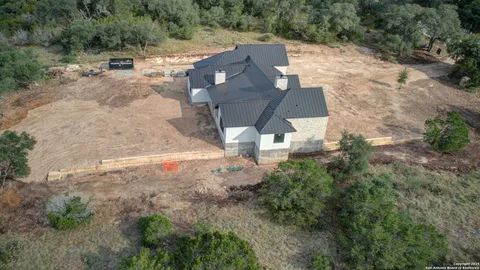 an aerial view of a house with a yard and trees