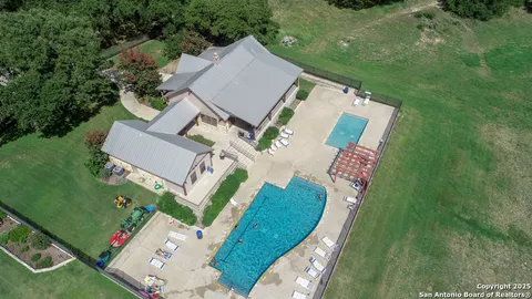 an aerial view of a house with outdoor space pool seating area and yard