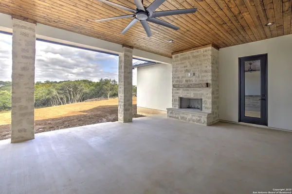 a view of an empty room with a fireplace and a window