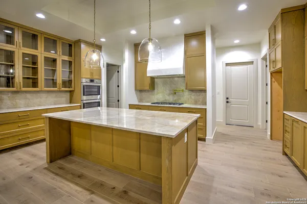 an open kitchen with granite countertop a sink and a refrigerator