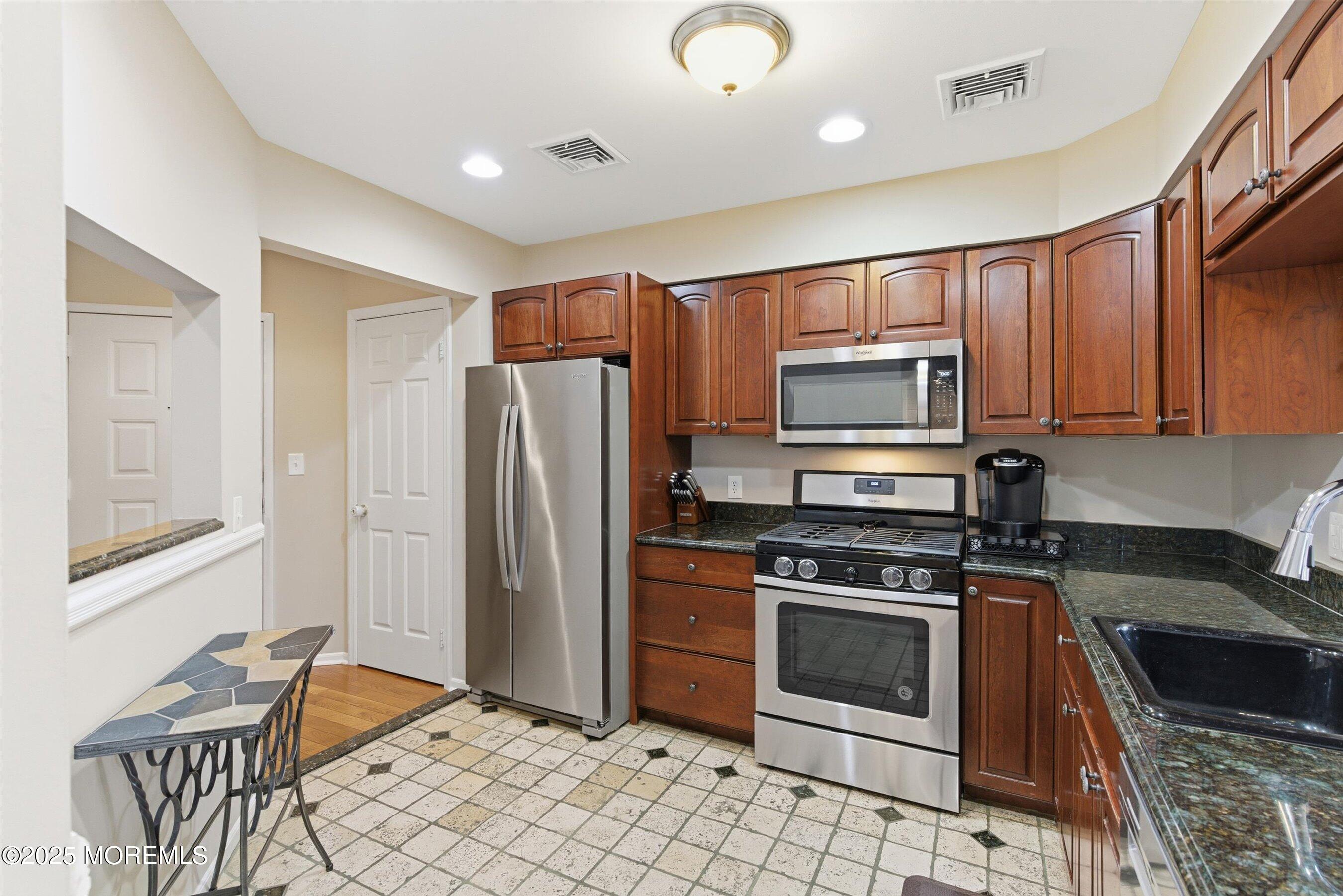 122 Quartz Lane Paterson, NJ 07501 - Photo 15 of 34 a kitchen with stainless steel appliances granite countertop a stove a sink and a refrigerator