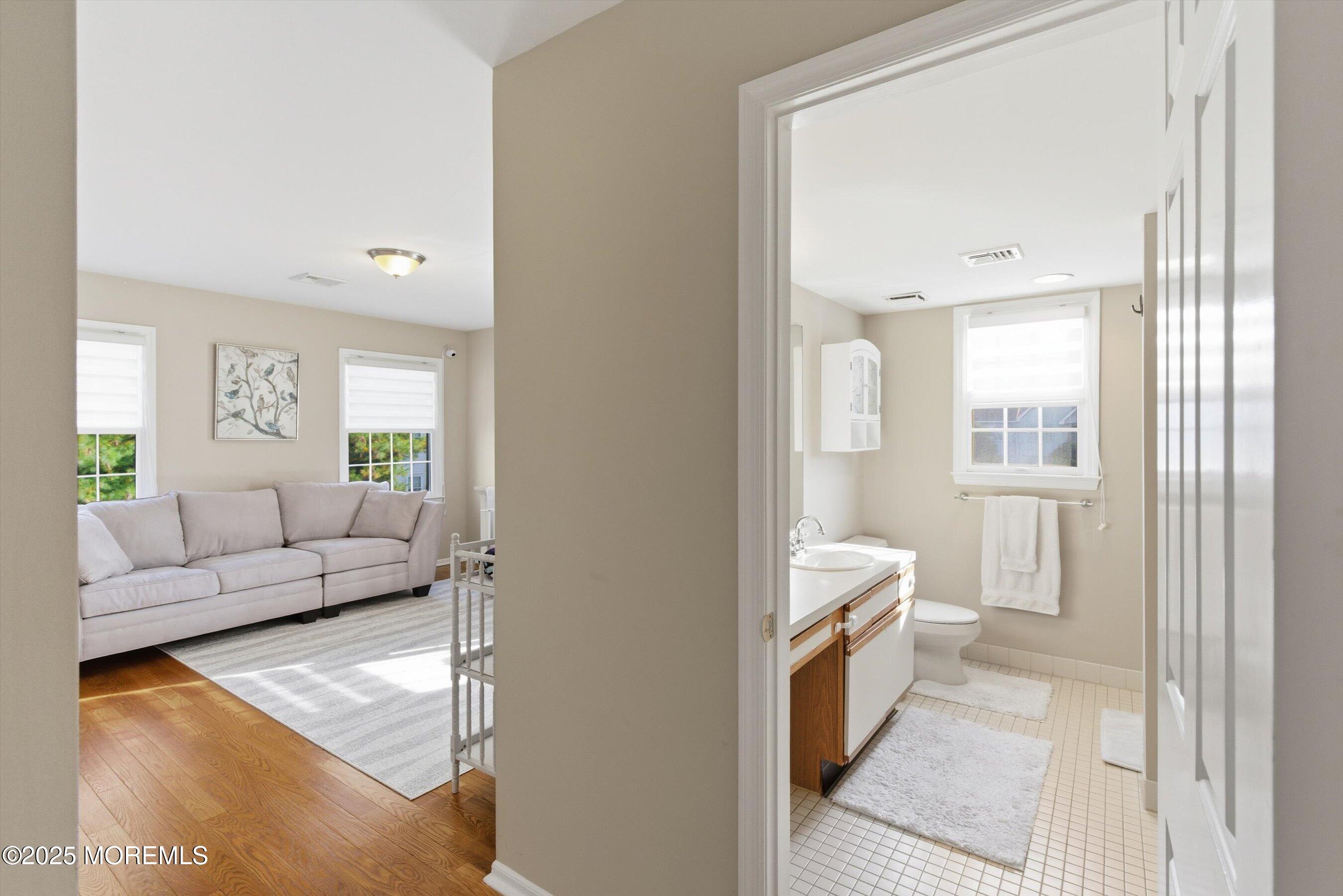 122 Quartz Lane Paterson, NJ 07501 - Photo 16 of 34 a living room with a couch and a dresser with wooden floor