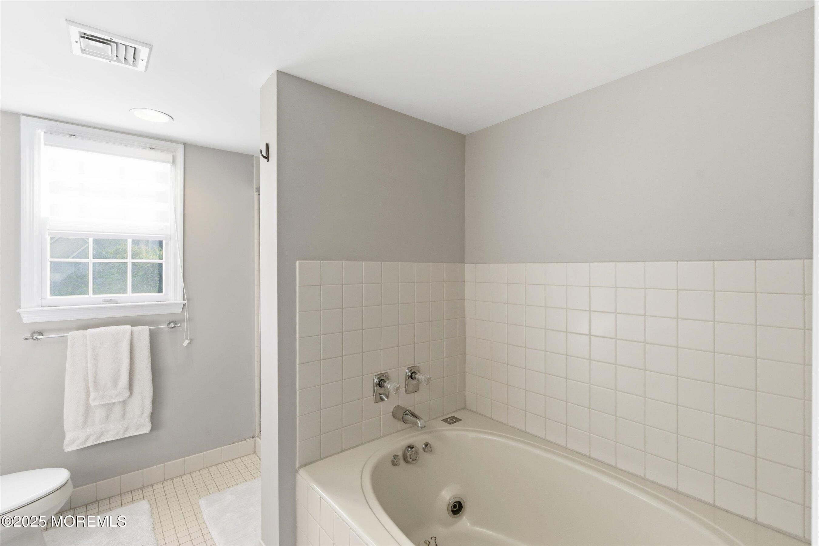 122 Quartz Lane Paterson, NJ 07501 - Photo 20 of 34 a bathroom with a bathtub and a toilet