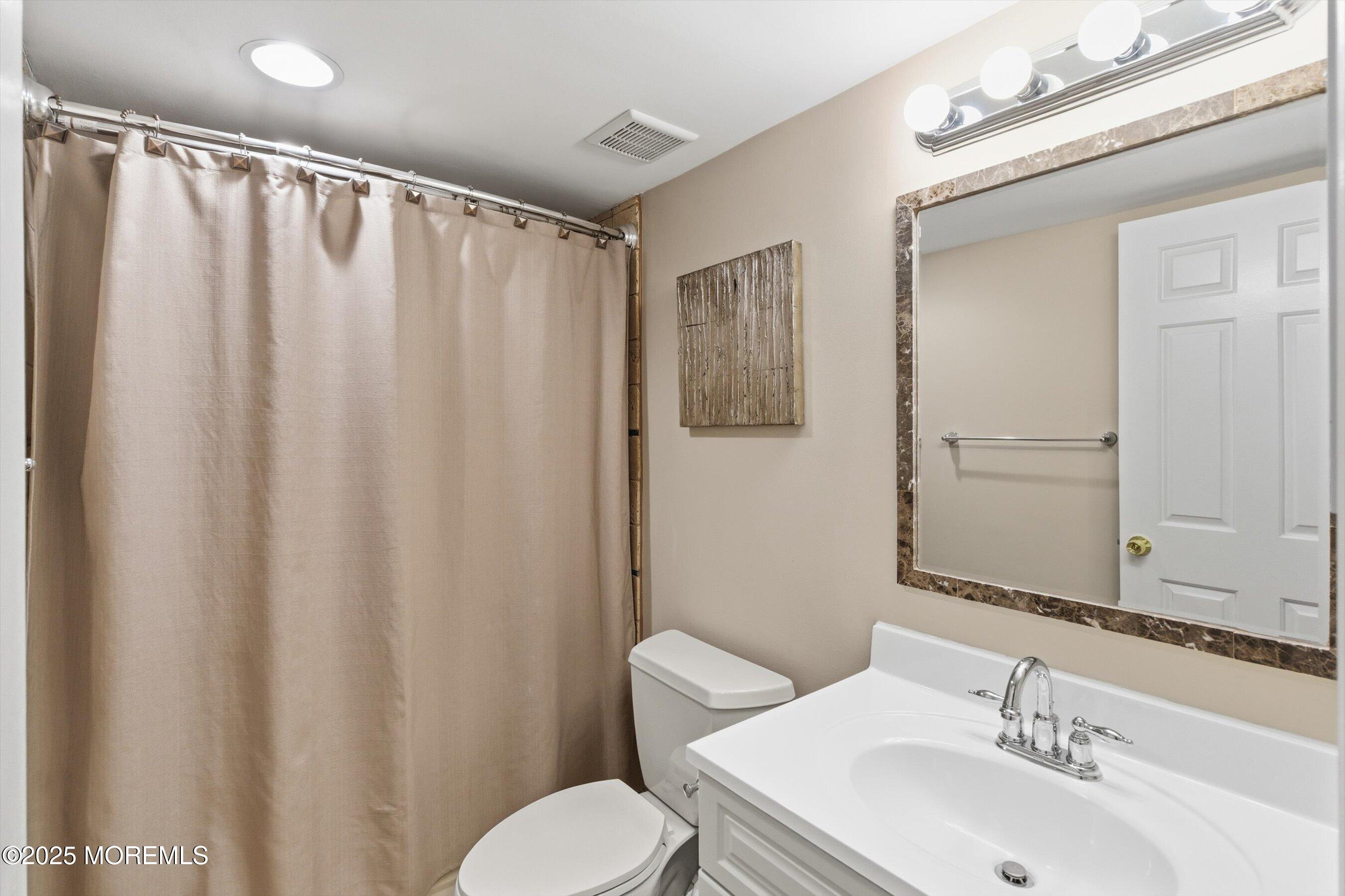 122 Quartz Lane Paterson, NJ 07501 - Photo 23 of 34 a bathroom with a sink a mirror and a toilet