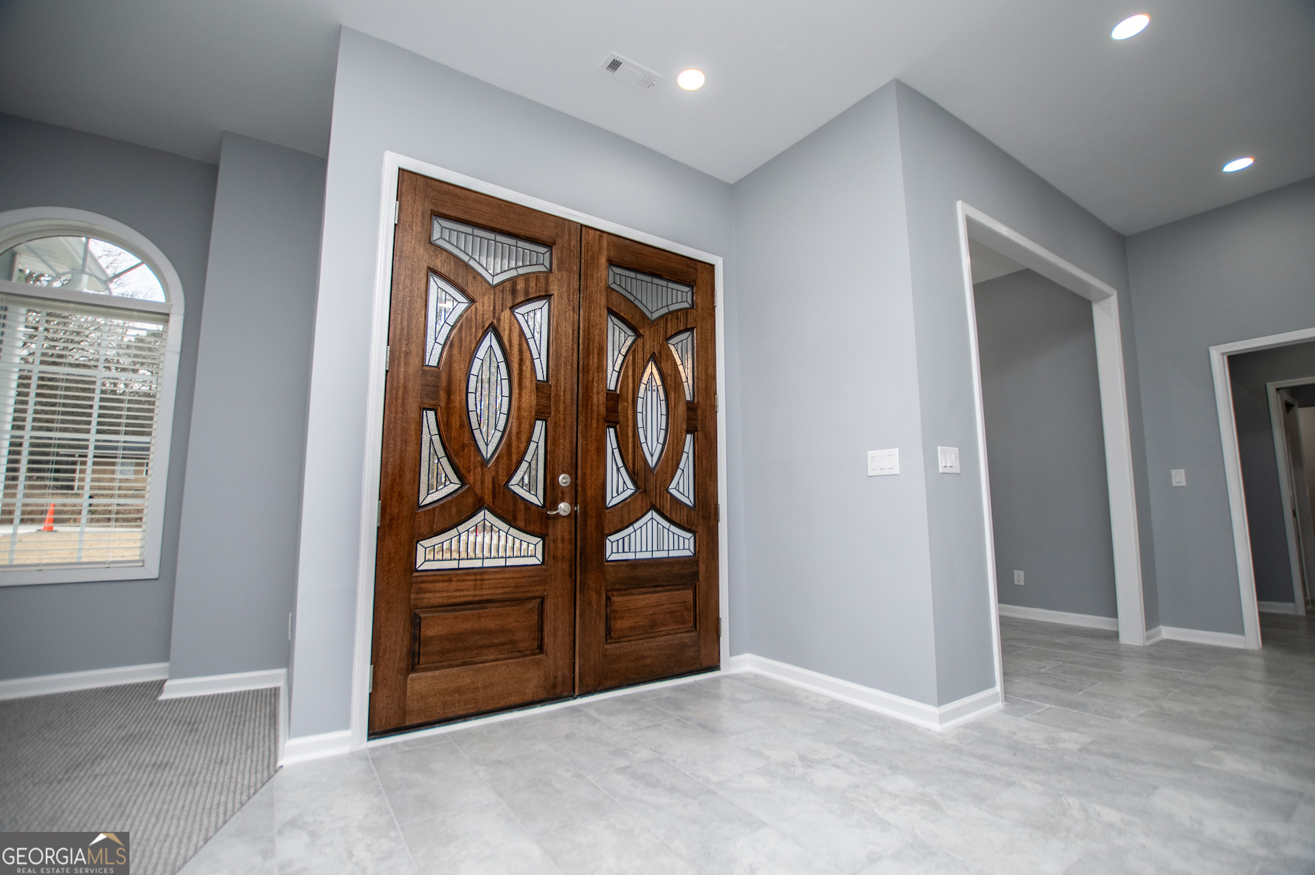 74 Jiles Road Carrollton, GA 30117 - Photo 6 of 130 an empty room with windows wooden floor and mirror