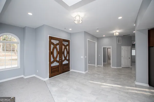 an empty room with a ceiling fan and carpet