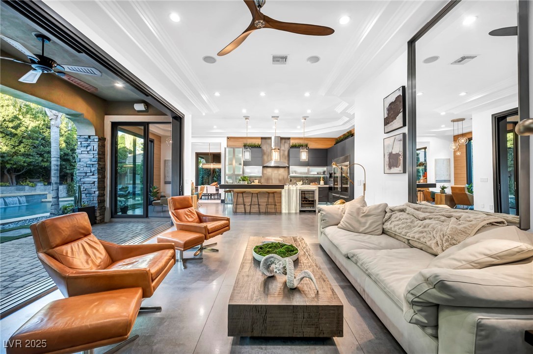 8032 Spring Buck Court Las Vegas, NV 89129 - Photo 15 of 41 Living area with crown molding, recessed lighting, Italian porcelain flooring, beverage cooler, and a ceiling fan