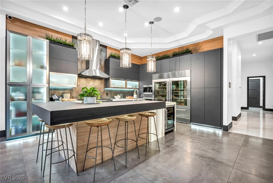 8032 Spring Buck Court Las Vegas, NV 89129 - Photo 16 of 41 Kitchen featuring a breakfast bar area, decorative light fixtures, stainless steel appliances, modern cabinets, and a large island