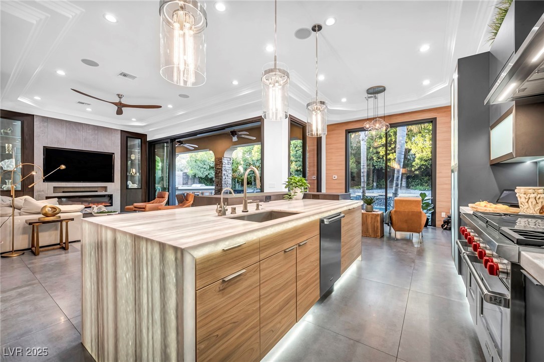 8032 Spring Buck Court Las Vegas, NV 89129 - Photo 17 of 41 Kitchen featuring modern cabinets, hanging light fixtures, wall chimney exhaust hood, plenty of natural light, and ornamental molding