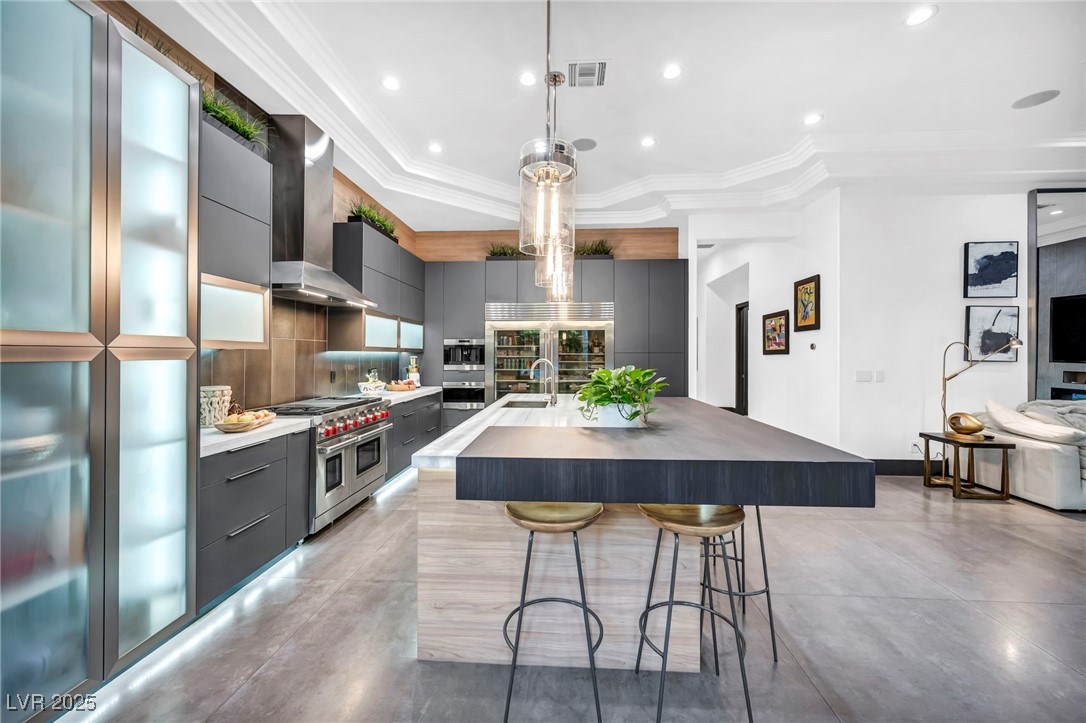 8032 Spring Buck Court Las Vegas, NV 89129 - Photo 19 of 41 Kitchen featuring a kitchen breakfast bar, pendant lighting, modern cabinets, a center island with sink, and recessed lighting
