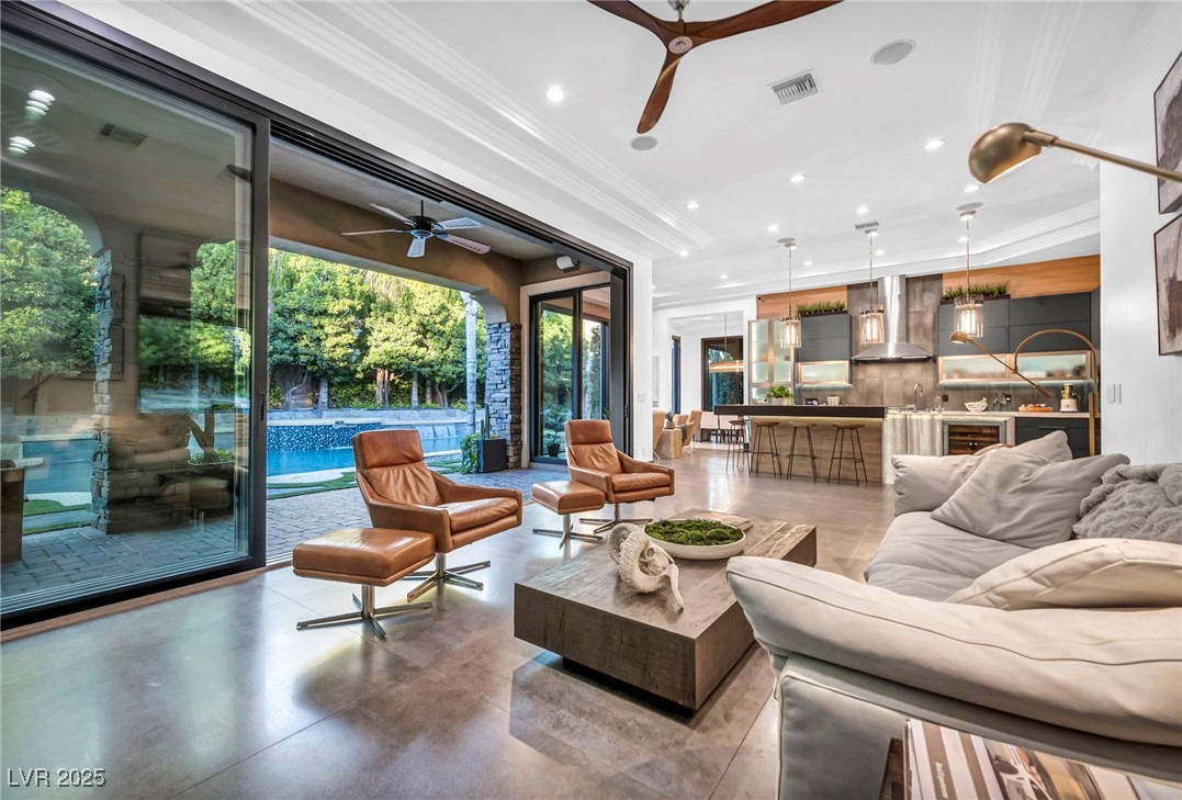 8032 Spring Buck Court Las Vegas, NV 89129 - Photo 3 of 41 Living area with recessed lighting, crown molding, a ceiling fan, and concrete flooring