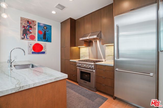 a kitchen with stainless steel appliances granite countertop a refrigerator and a stove