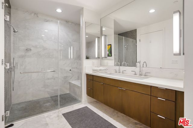 a bathroom with a double vanity sink mirror and shower
