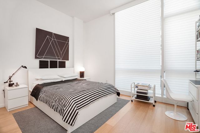 a bedroom with a bed a lamp and a window