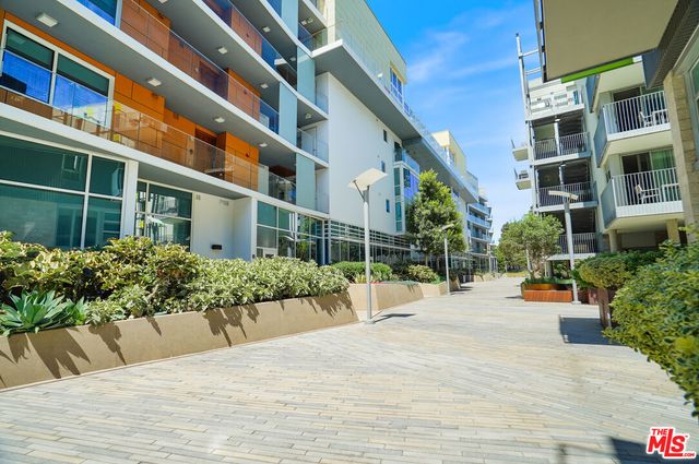 a view of a building with potted plants and a bench