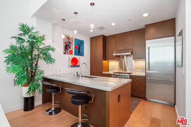 a kitchen with stainless steel appliances granite countertop a sink and a refrigerator
