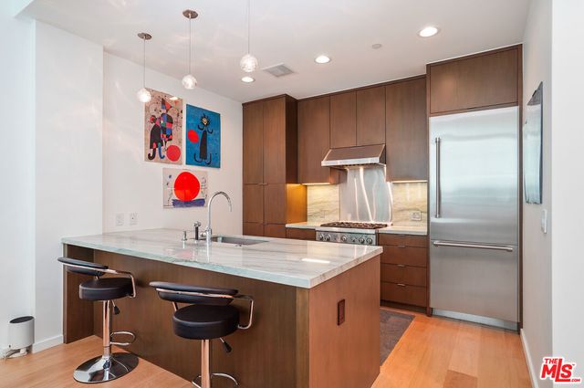 a kitchen with stainless steel appliances granite countertop a sink and a refrigerator