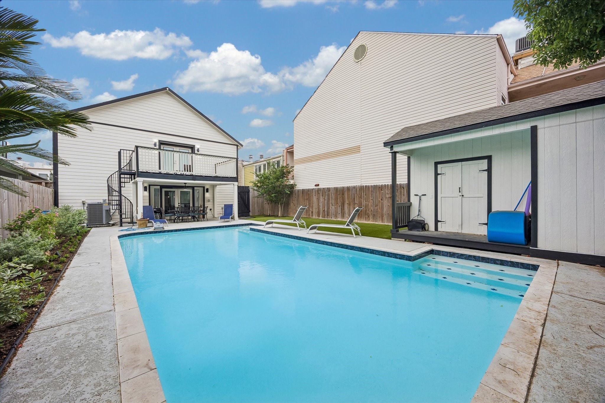 This property features a spacious backyard with a large swimming pool, surrounded by a well-maintained patio area. There's  a shed for storage.  This is  a perfect space for relaxation and entertainment.
