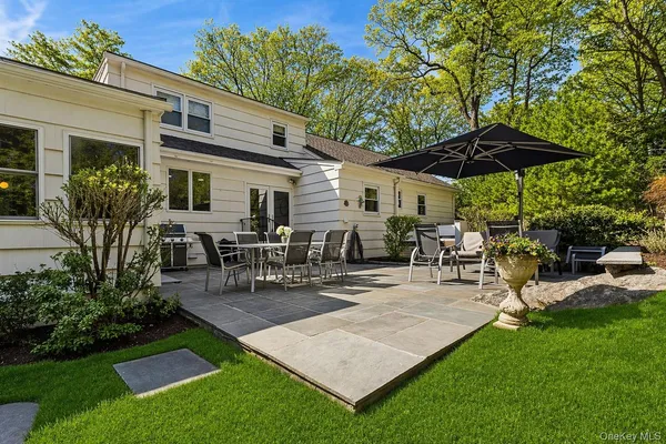 a view of a patio with table and chairs under an umbrella