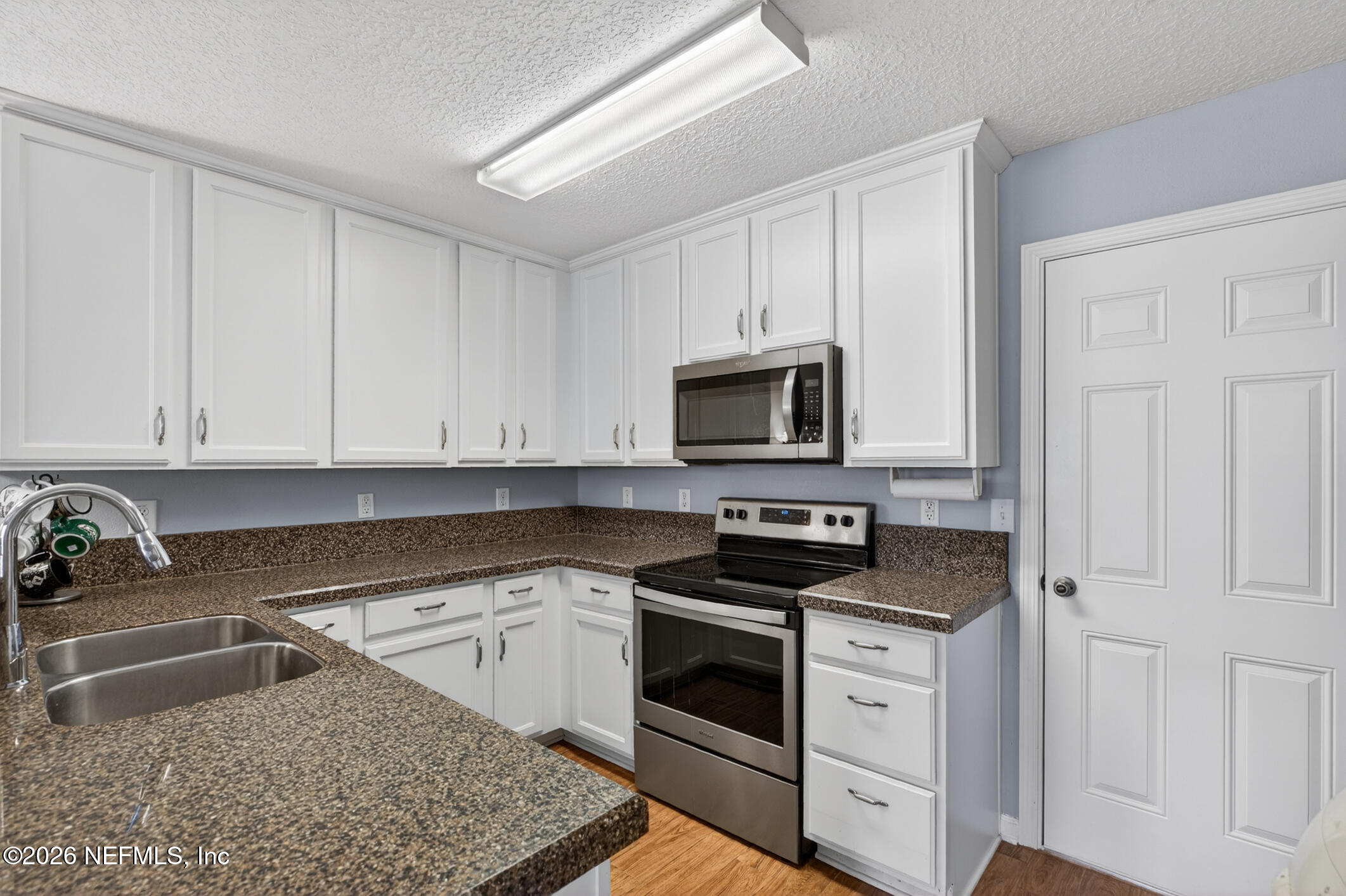 1500 Calming Water Drive, Unit 4603 Fleming Island, FL 32003 - Photo 17 of 98 a kitchen with white cabinets and white appliances
