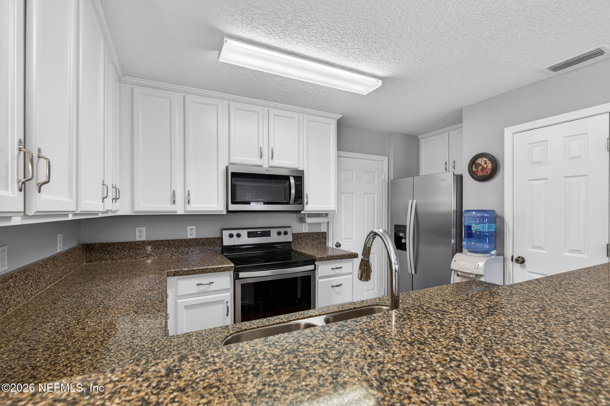1500 Calming Water Drive, Unit 4603 Fleming Island, FL 32003 - Photo 26 of 98 a kitchen with stainless steel appliances granite countertop a stove a sink and a refrigerator