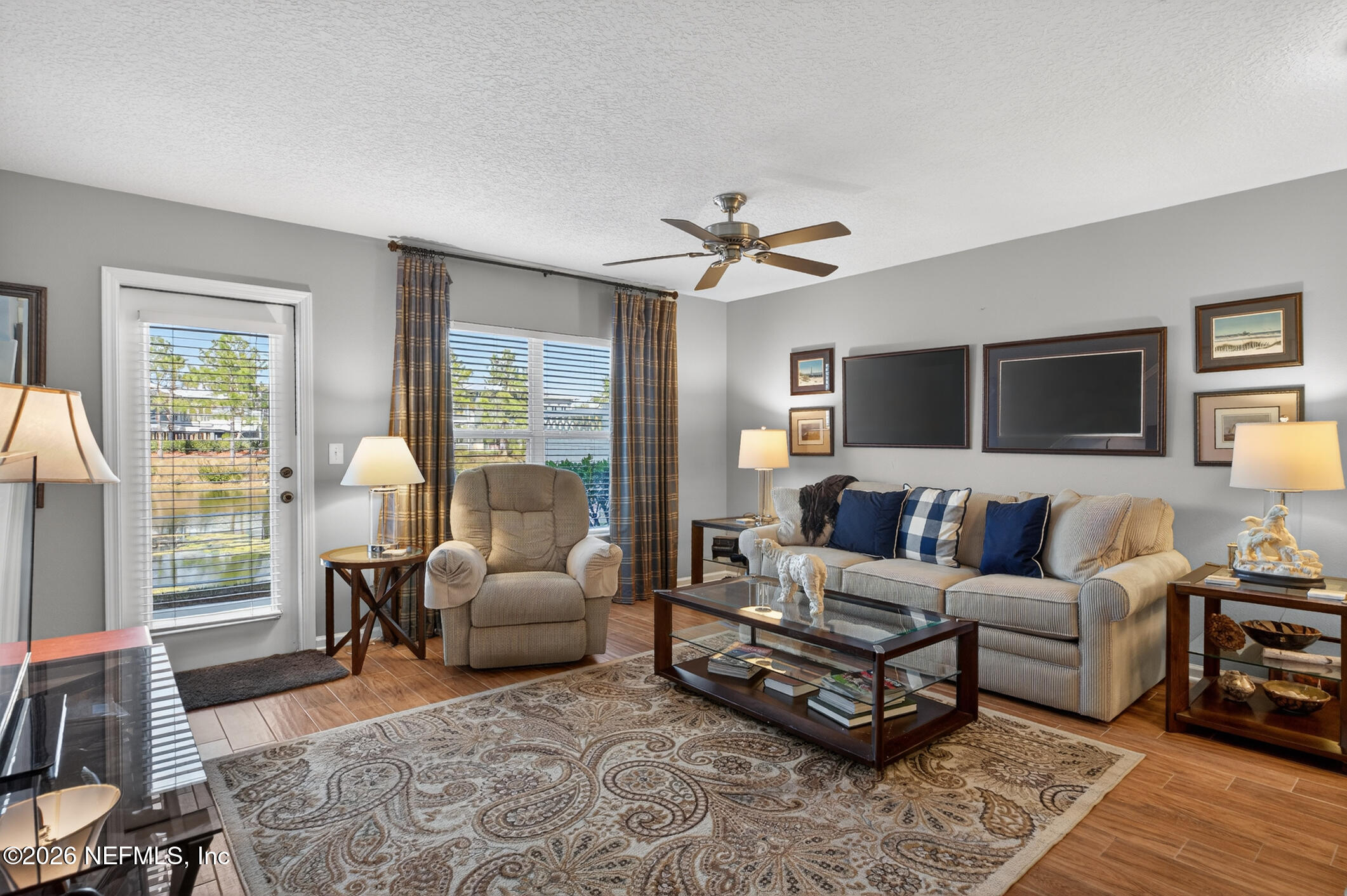 1500 Calming Water Drive, Unit 4603 Fleming Island, FL 32003 - Photo 29 of 98 a living room with furniture a ceiling fan a fireplace and a large window