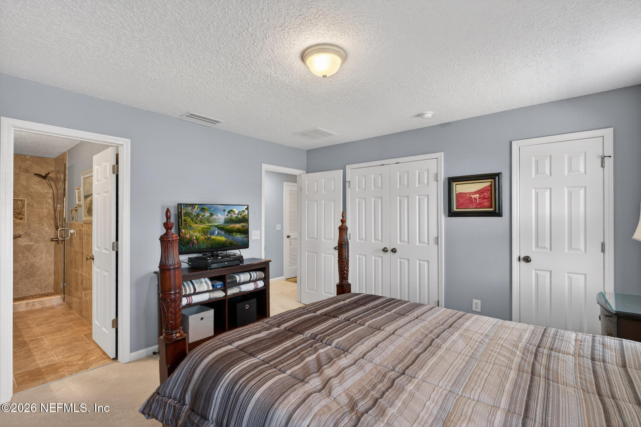 1500 Calming Water Drive, Unit 4603 Fleming Island, FL 32003 - Photo 37 of 98 a bedroom with a bed and a flat screen tv