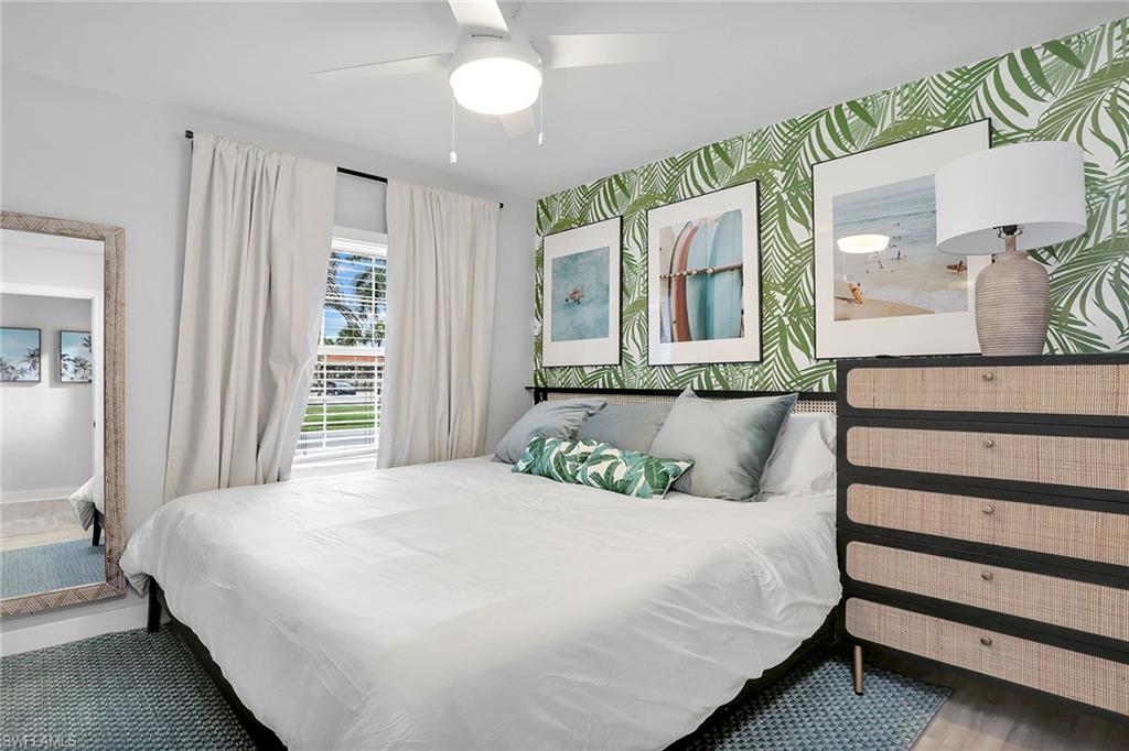 2780 Weeks Avenue Naples, FL 34112 - Photo 11 of 34 a bedroom with a large bed and a chandelier