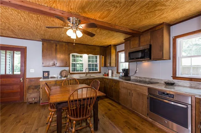 a kitchen with a stove a sink a microwave and wooden cabinets