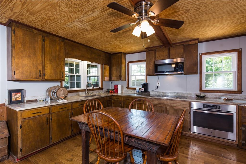 933 Alto-Mud Creek Road Alto, GA 30510 - Photo 17 of 41 a kitchen with a stove a sink a microwave and wooden cabinets