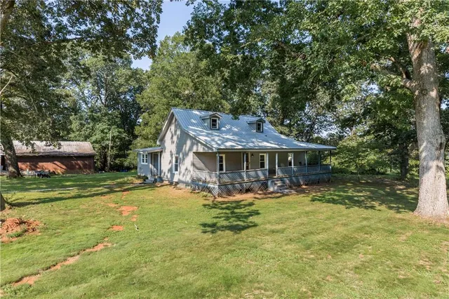 a view of a big house with a big yard and large trees