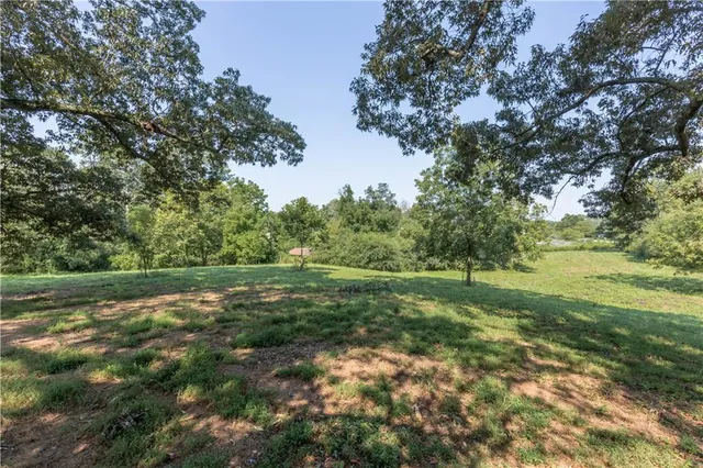 a view of outdoor space with green field and trees all around