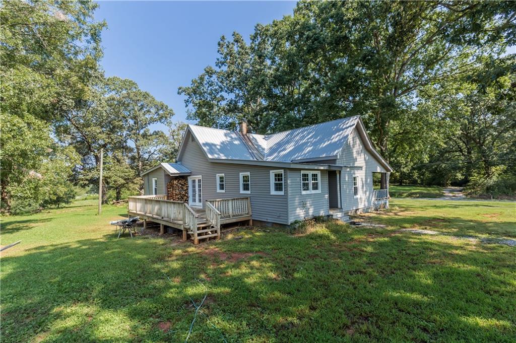 933 Alto-Mud Creek Road Alto, GA 30510 - Photo 8 of 41 a house that is sitting in the grass with large trees and plants
