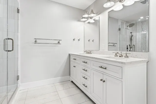 a bathroom with a double vanity sink a mirror and a shower