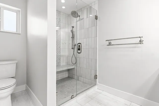 a bathroom with a granite countertop shower and toilet