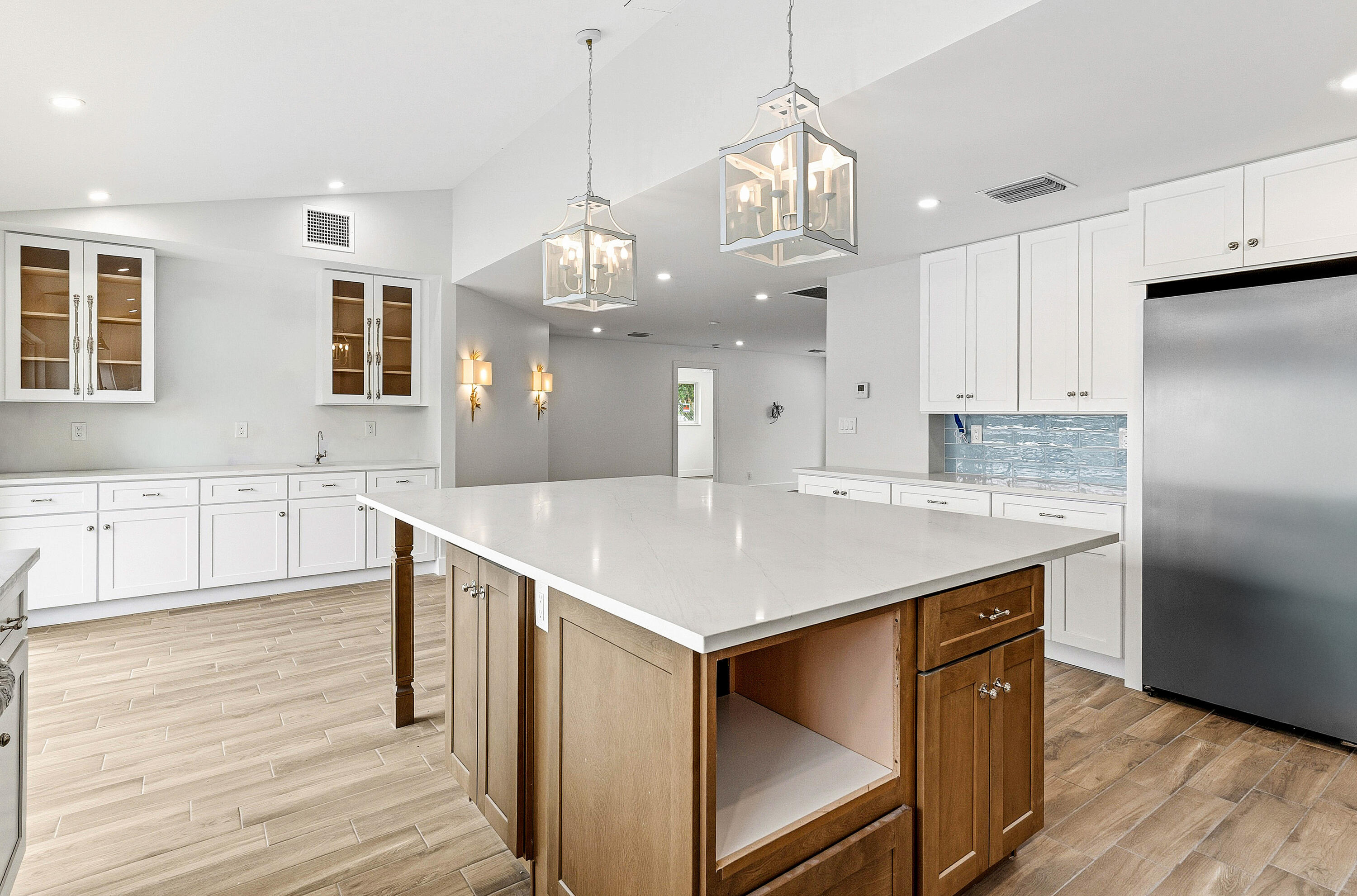 1254 Southwest 4th Court Boca Raton, FL 33432 - Photo 8 of 35 a kitchen with kitchen island a island a stove a refrigerator and a sink