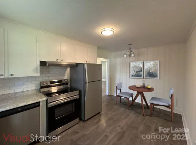 a kitchen with a refrigerator and a stove top oven