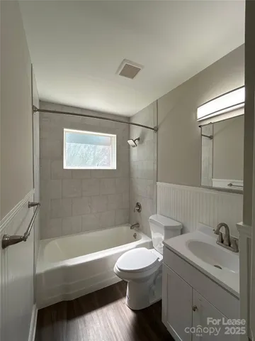 a bathroom with a bathtub shower sink mirror and toilet