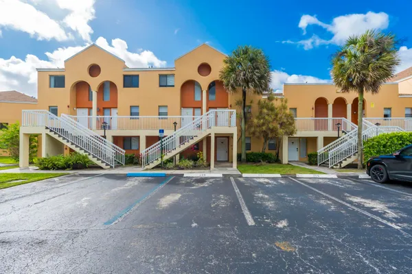 a front view of a house with a yard and potted plants
