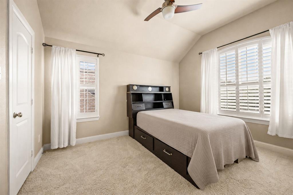 1521 Newton Ranch Road Keller, TX 76248 - Photo 29 of 40 Vaulted ceiling with a ceiling fan, plush carpeting, two windows with plantation shutters, and a white paneled door