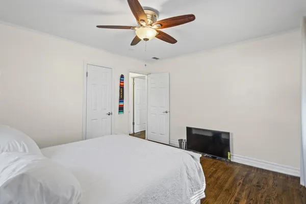 a bedroom with a bed and a ceiling fan