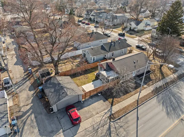 a view of a brick house next to a yard with large tree