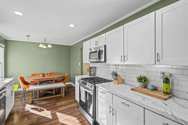 a kitchen with stainless steel appliances granite countertop a stove a sink and a white cabinets