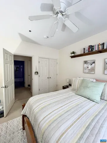 a bedroom with a bed and a ceiling fan