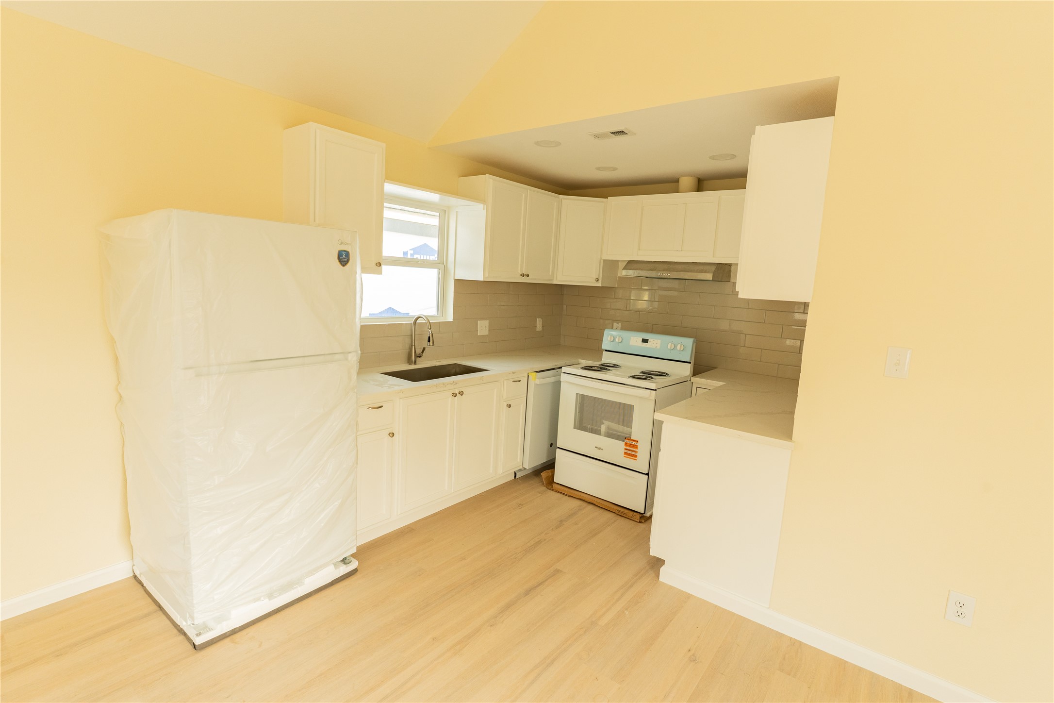 4425 7th Street Bacliff, TX 77518 - Photo 6 of 16 a kitchen with white cabinets and white appliances